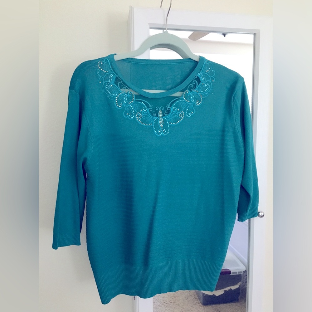 Beautiful turquoise knit top with embellished neckline.